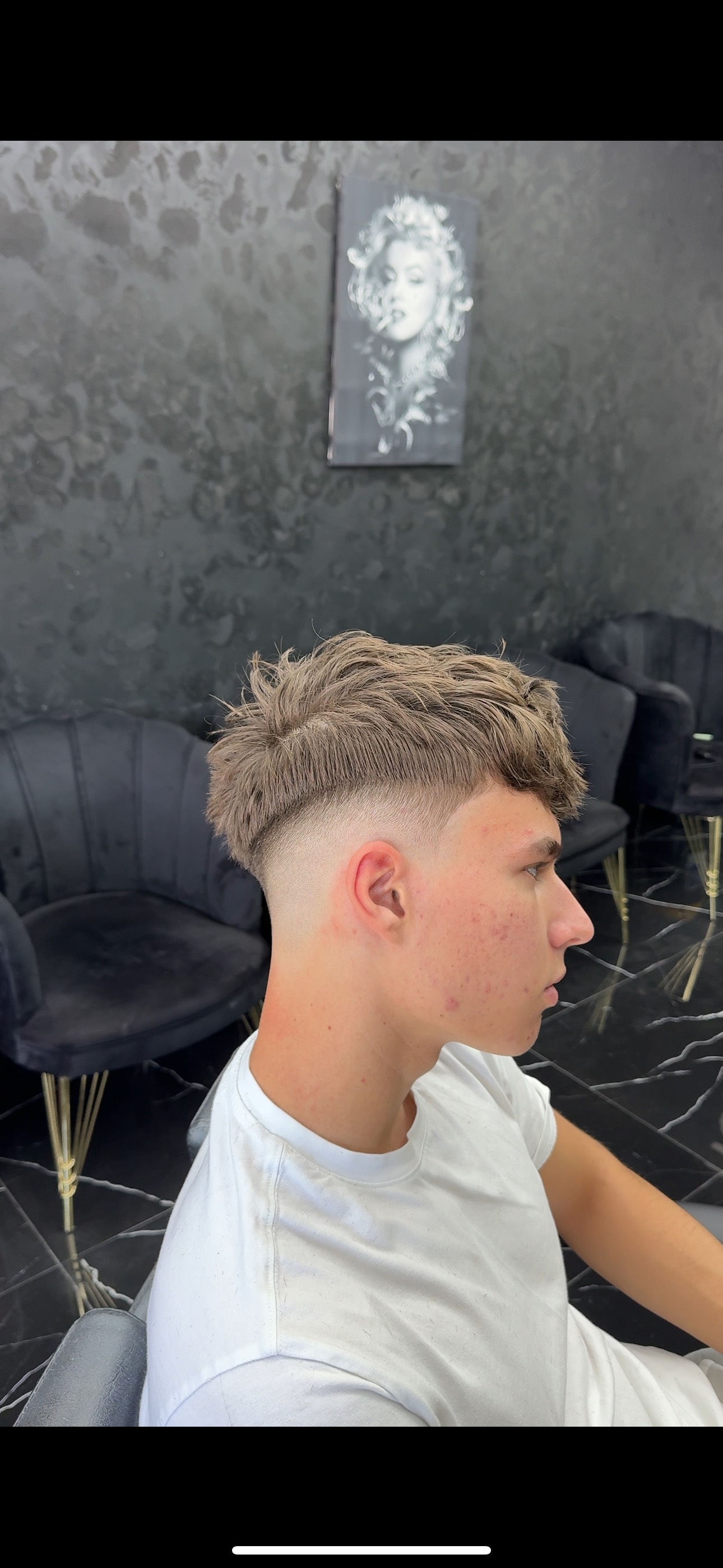 Client al frizeriei cu tunsoare de tip High Fade si cu parul verde